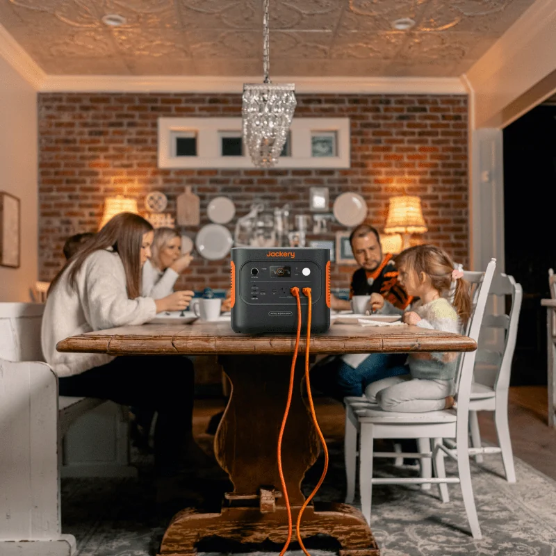 Jackery Explorer 2000 v2 – home backup at the dinner table Jackery Explorer 2000 v2 powering lights at a family dinner table during an outage